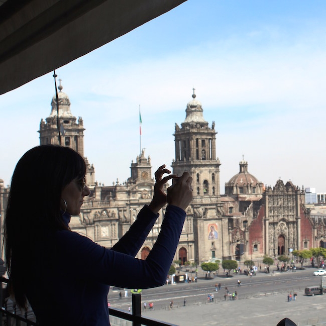 silhouette of Marcela Cardillo taking photo of city below